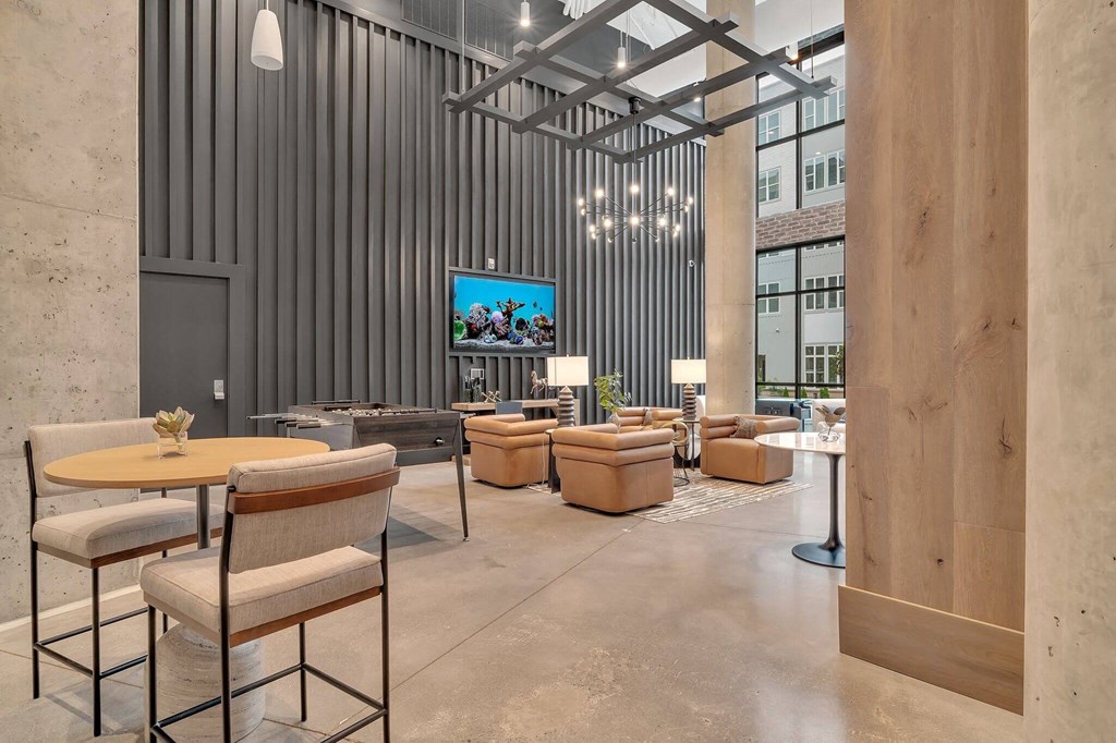 a lobby with chairs and tables and a tv