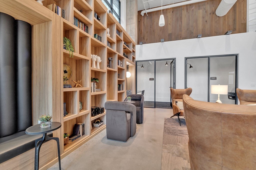 a living room with wooden shelves and couches and chairs