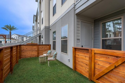a patio with a table and chairs in front of a building