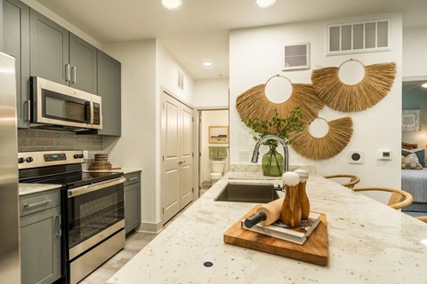 a kitchen with stainless steel appliances and a marble counter top