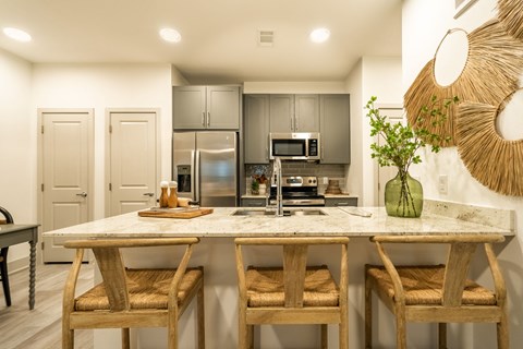 a kitchen with a marble counter top with three stools