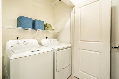 a washer and dryer in a laundry room with a white door