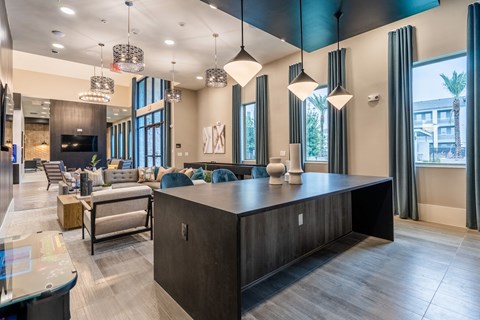 a communal area with a kitchen island and a living room with couches