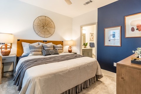 a blue accent wall in a bedroom with a bed