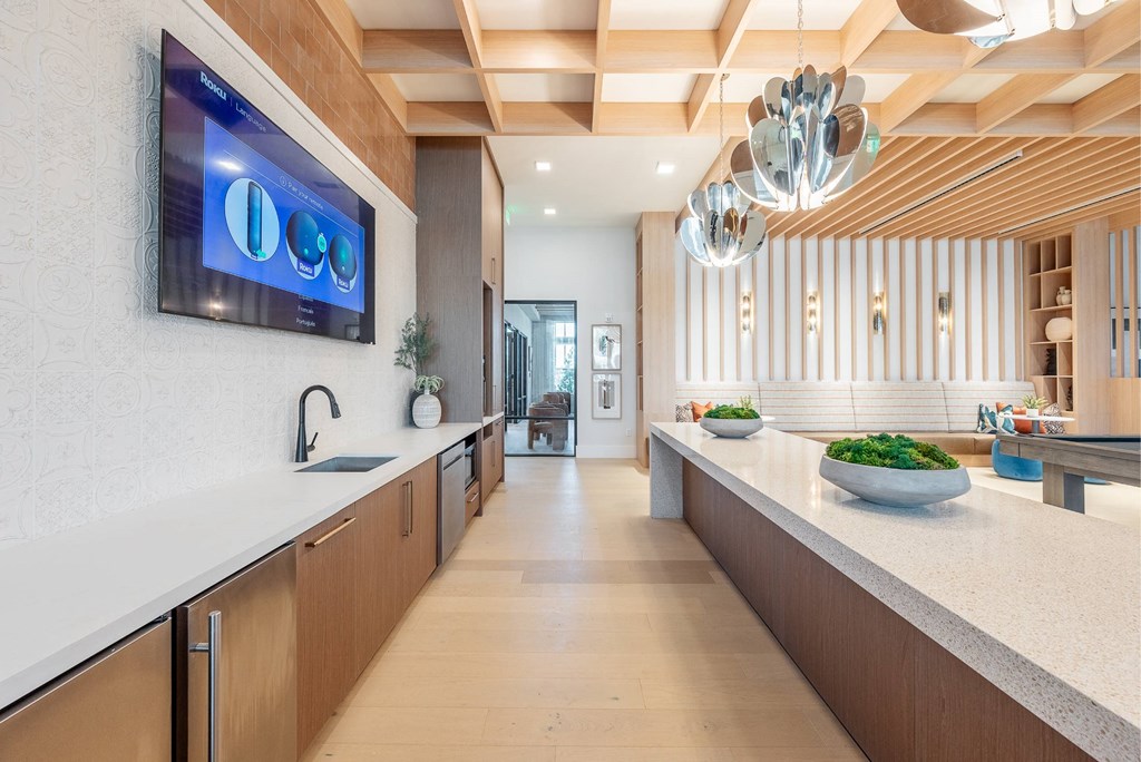 a kitchen with a counter top and a tv on the wall