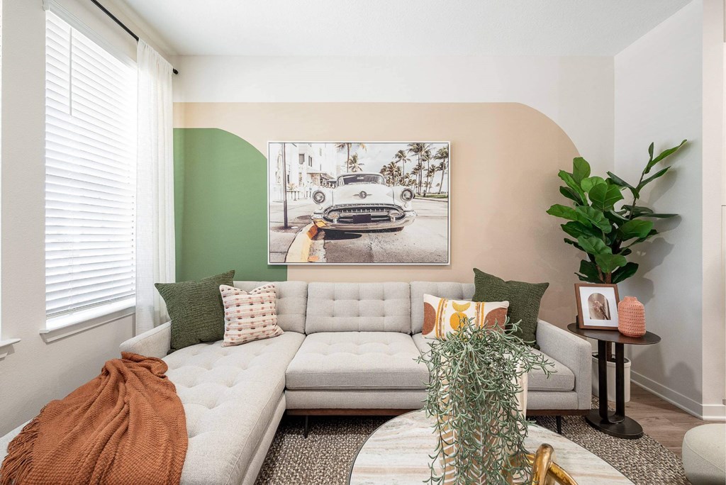 a living room with a couch and a painting on the wall