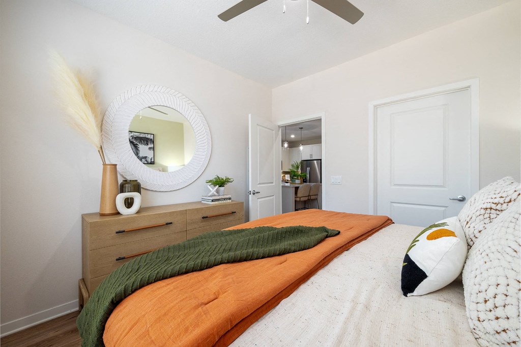 a bedroom with a bed and a mirror on the wall