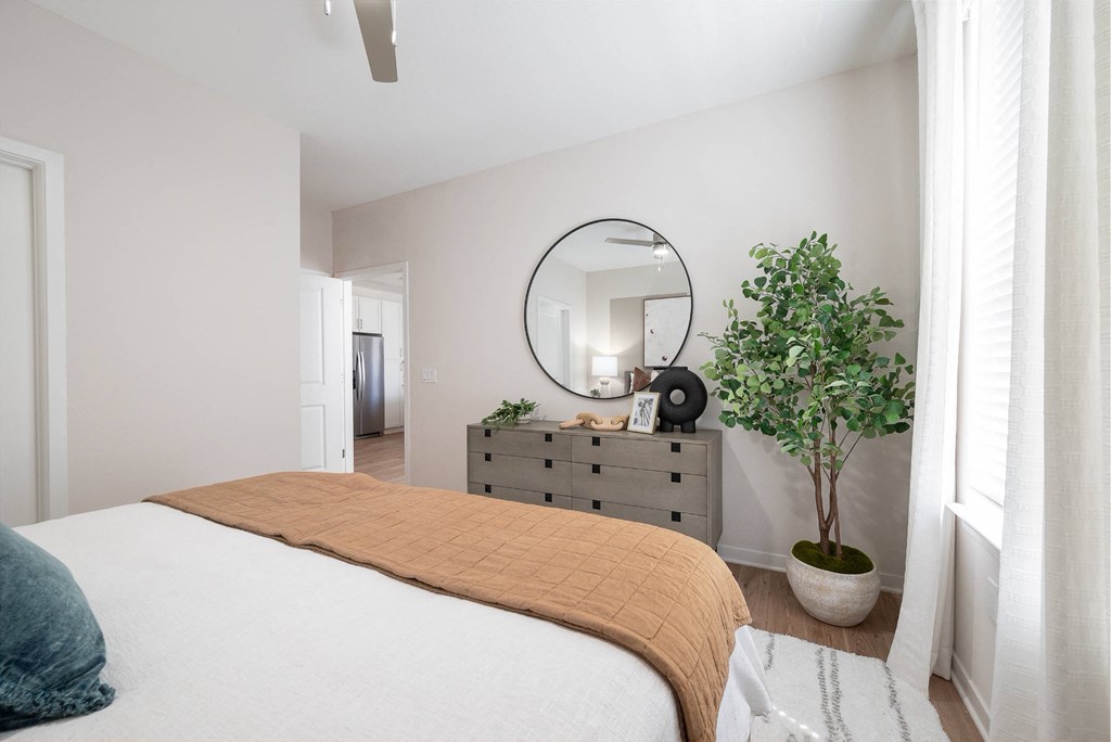 a bedroom with a bed and a dresser with a mirror