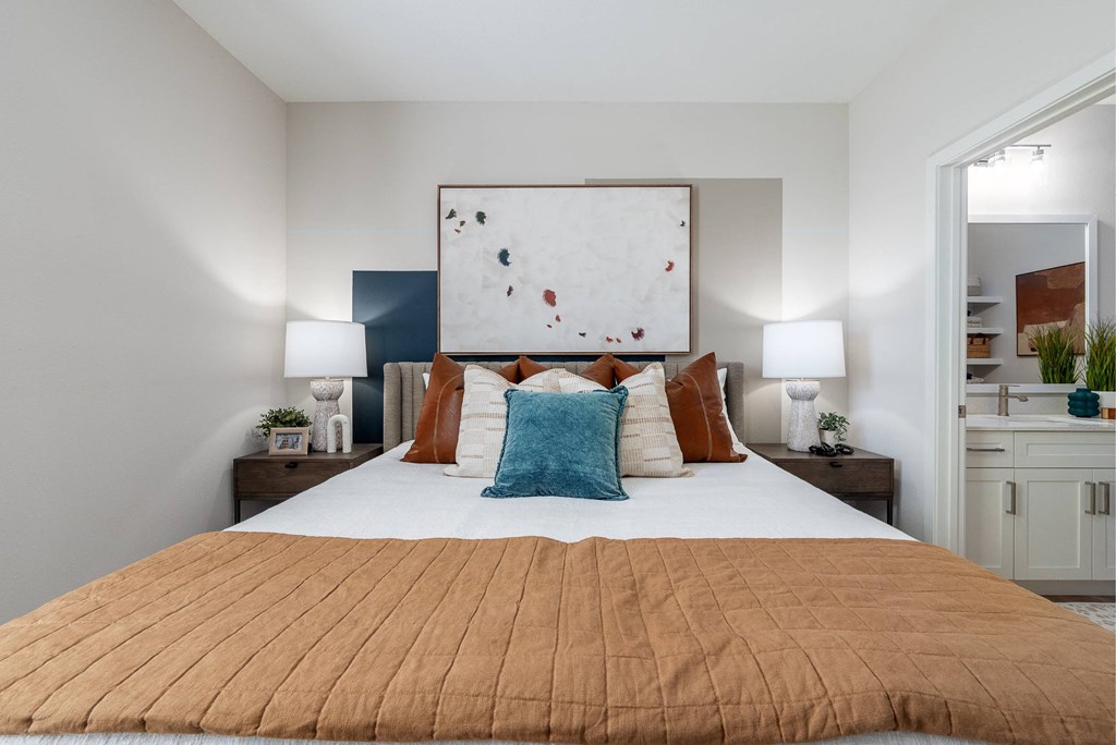 a bedroom with a large bed and a painting on the wall