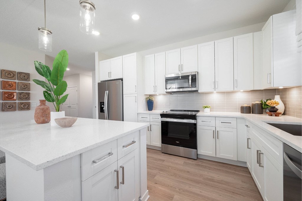 a kitchen with white cabinets and a white counter top