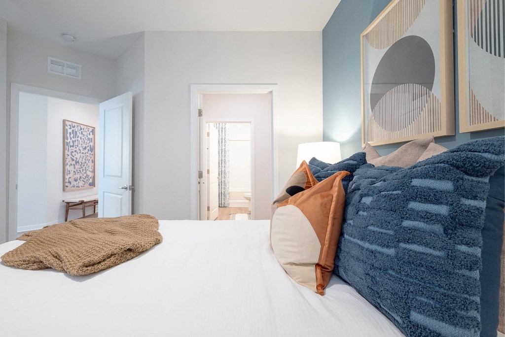 a bedroom with a large bed and a mirror on the wall