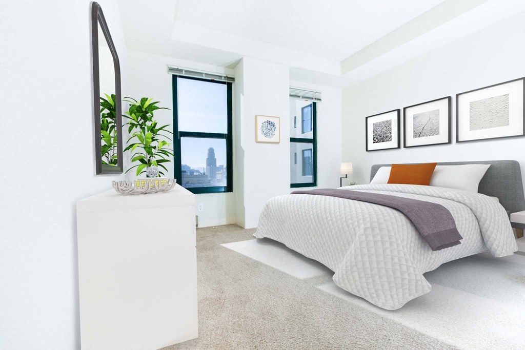a bedroom with a bed and a plant on a white dresser