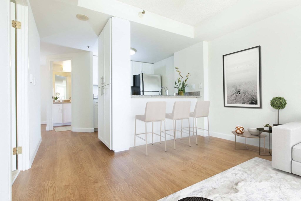 a white living room with a bar and a kitchen