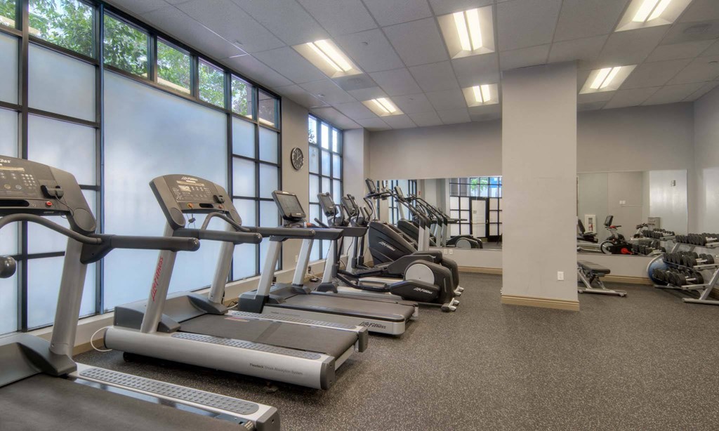 a rendering of a gym with cardio machines and chairs