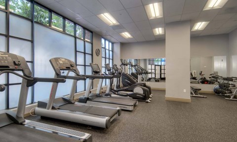 a rendering of a gym with cardio machines and chairs