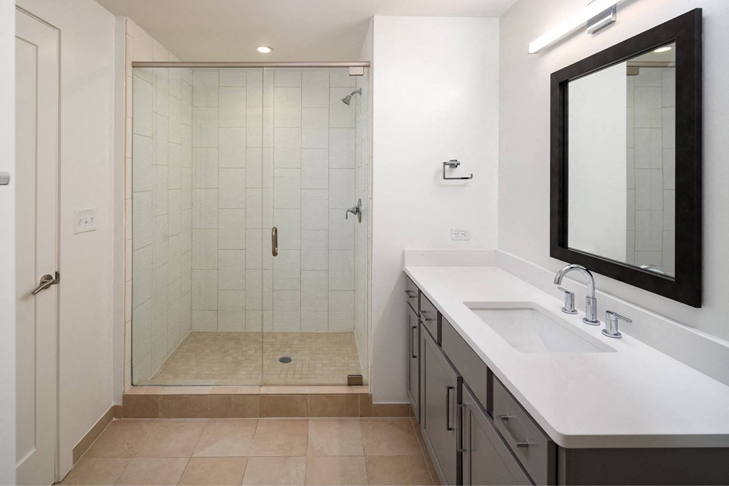 a bathroom with a shower and a sink and a mirror
