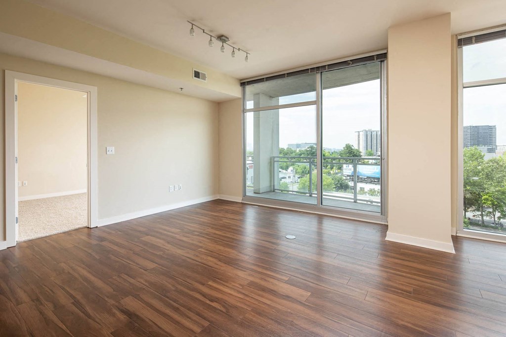 an empty living room with wood floors and a window
