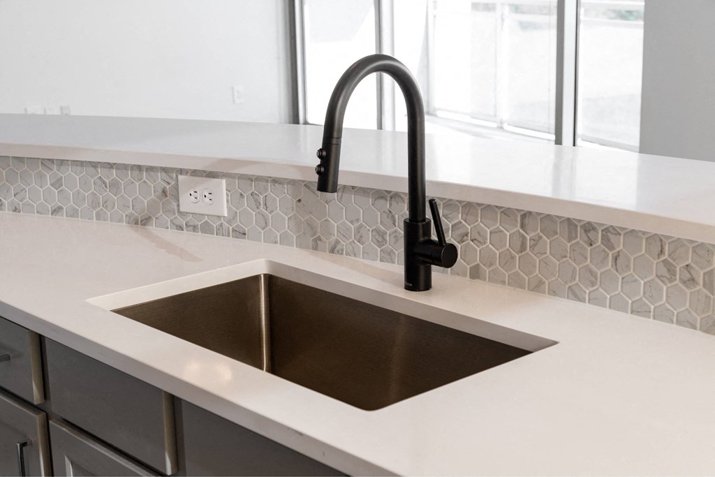 a kitchen with a sink and a black faucet