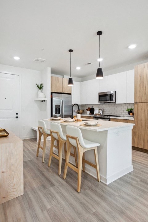 a kitchen with a large island with three chairs