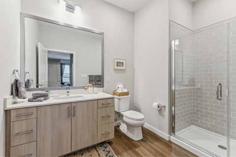 a bathroom with a toilet sink and shower and a mirror