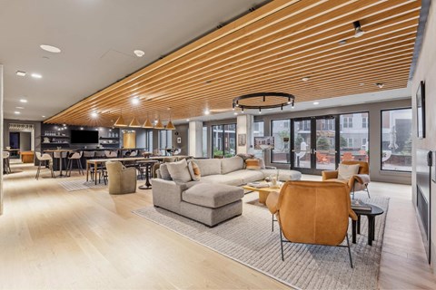 a living room with couches and chairs and tables and a kitchen