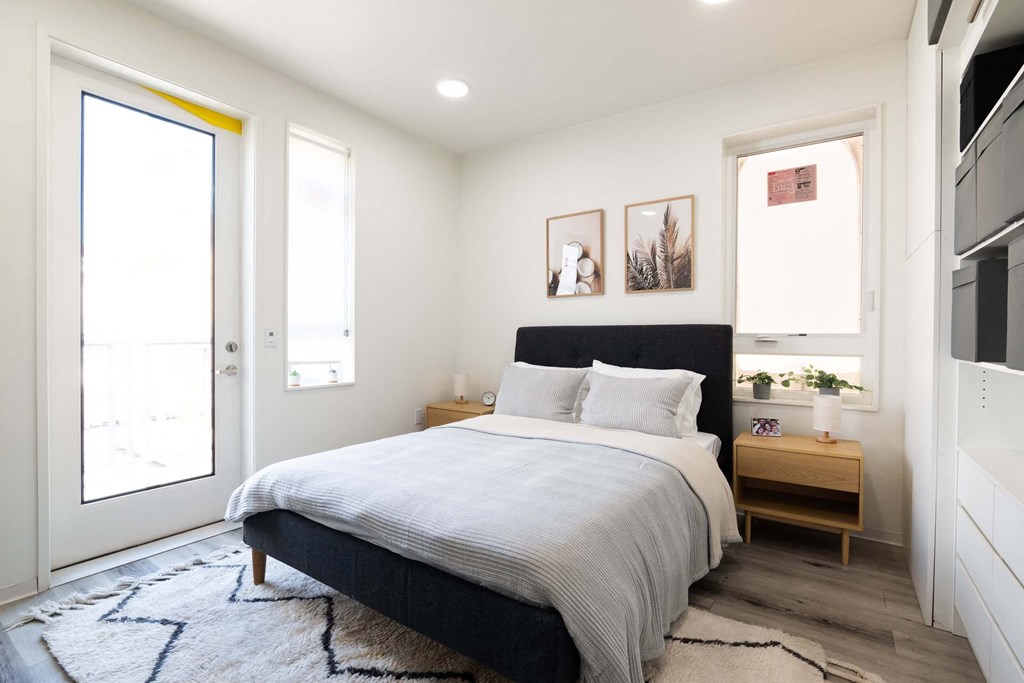 a bedroom with a bed and two windows