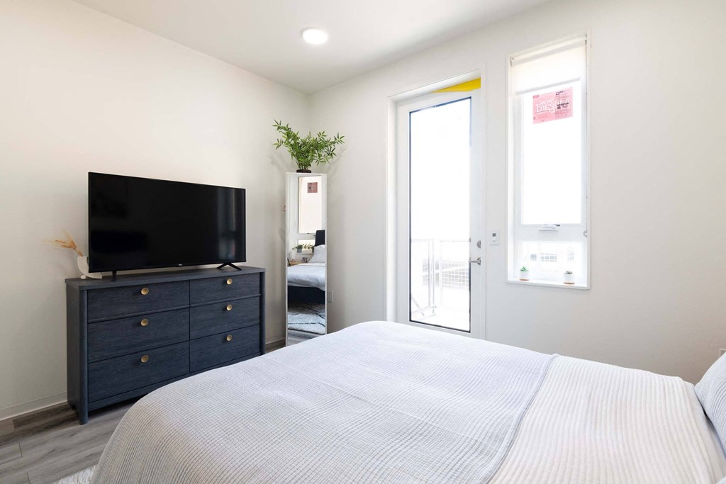 a bedroom with a bed and a tv      and a door