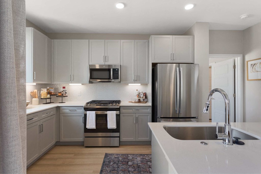 a kitchen with white cabinets and stainless steel appliances