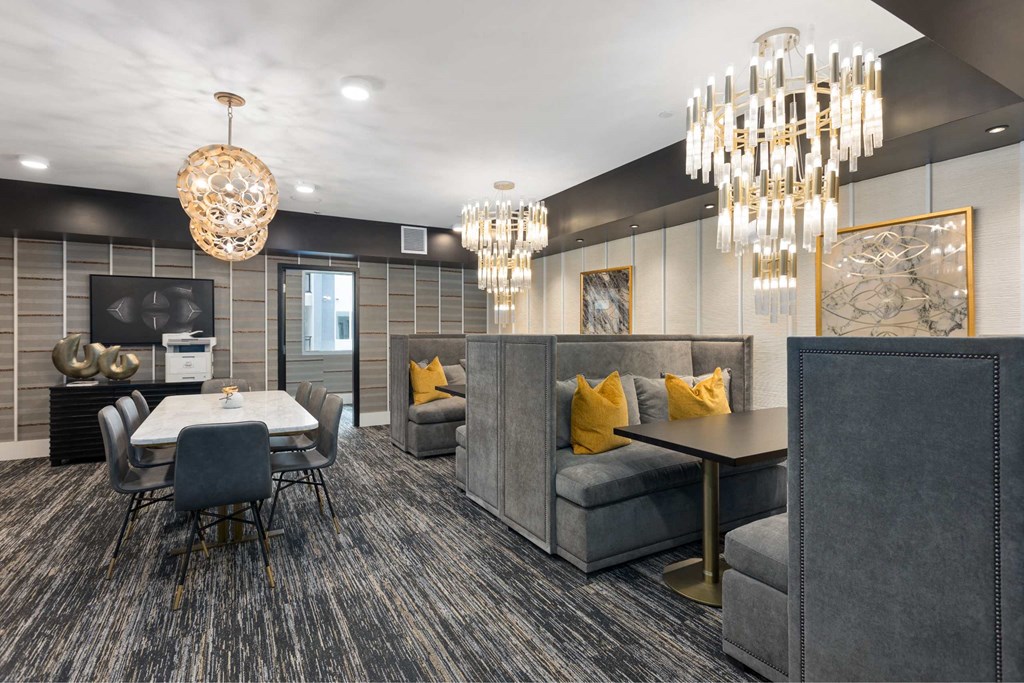 a living room and dining room with chandeliers and couches