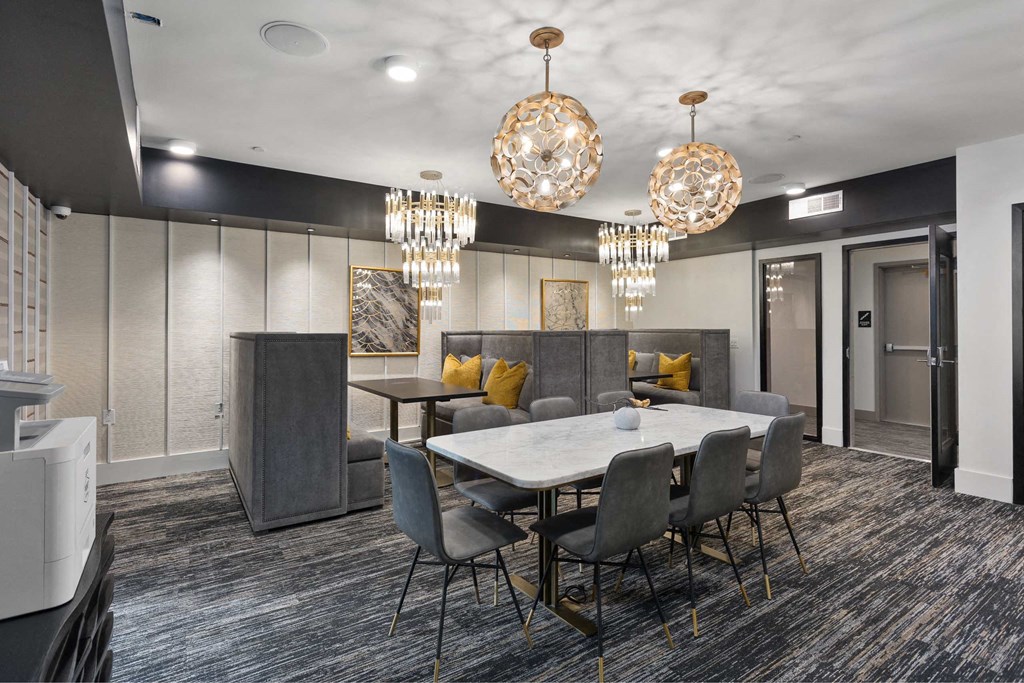 a conference room with a table and chairs and chandeliers