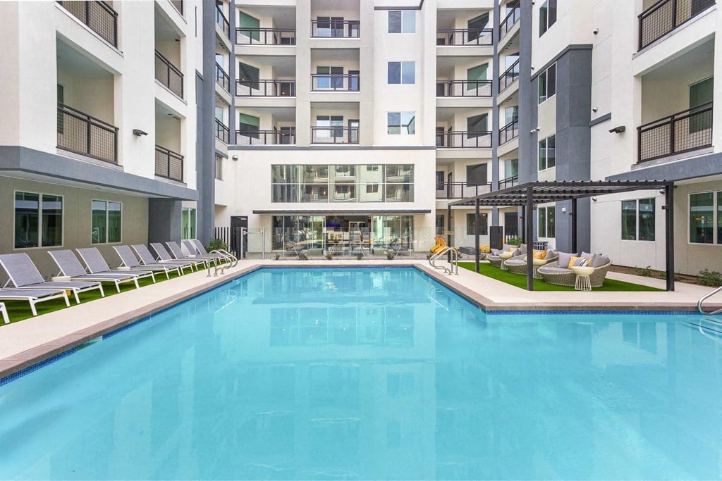 a large swimming pool in front of an apartment building
