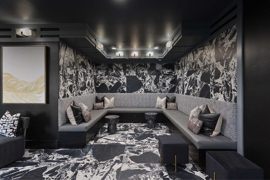 a cinema room with couches and a wall covered in black and white wallpaper