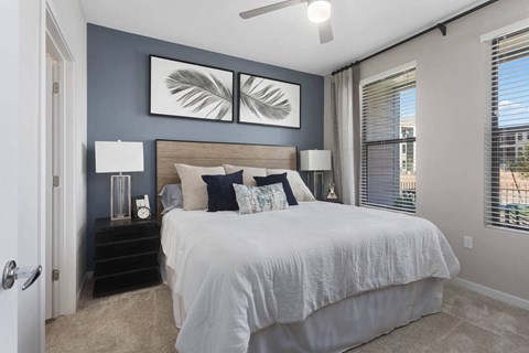 a bedroom with a bed and two windows