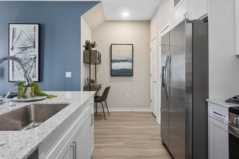 a kitchen with a stainless steel refrigerator and a sink