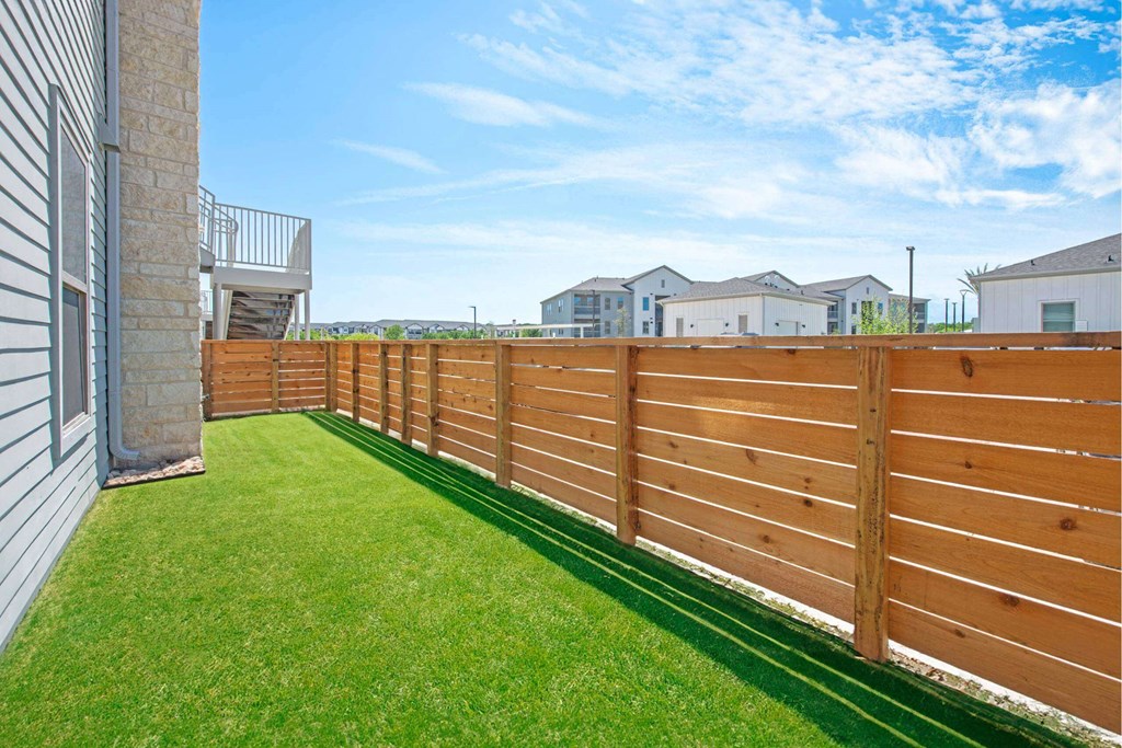 a wooden fence in a backyard next to a house