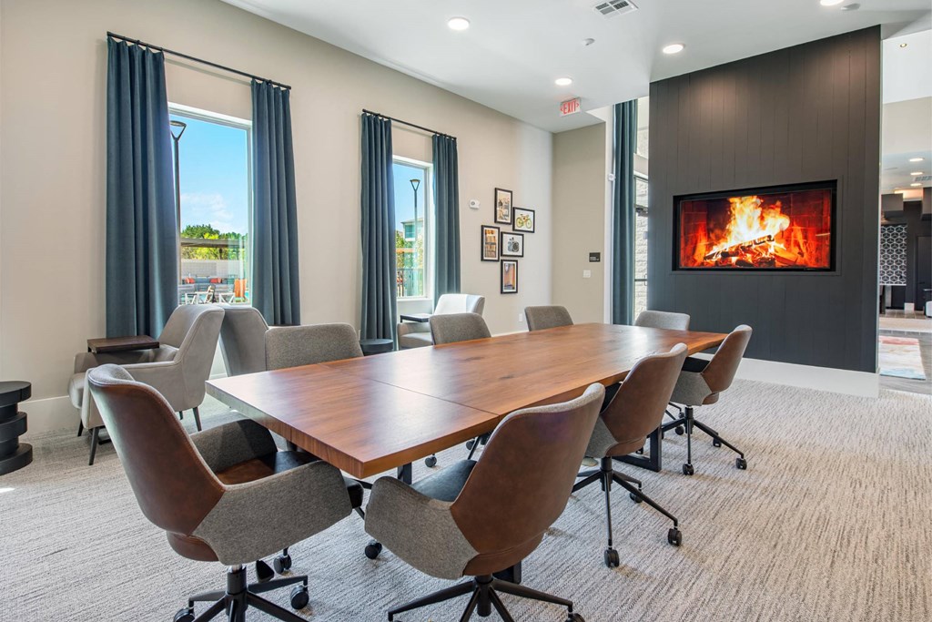 a conference room with a fireplace and a table and chairs