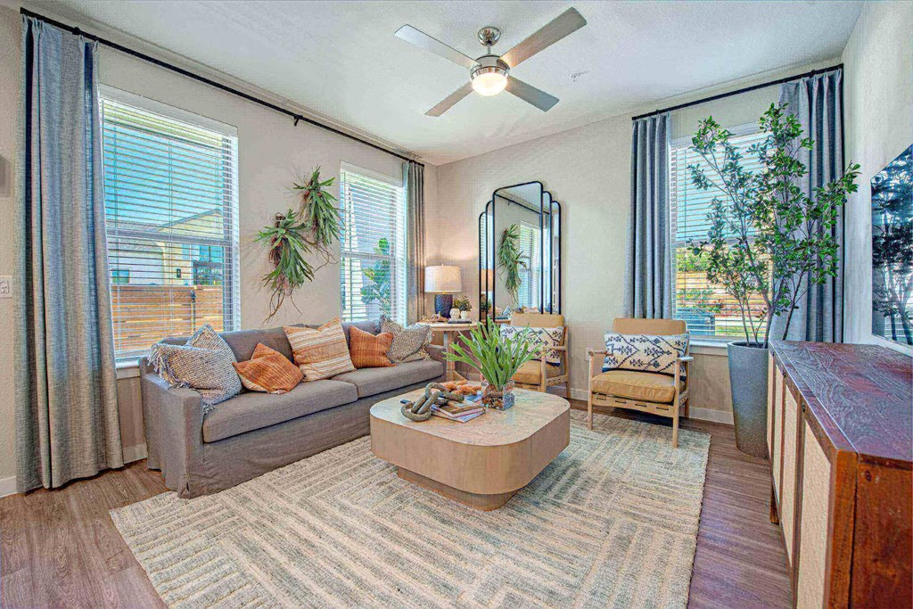 a living room with a couch and a ceiling fan