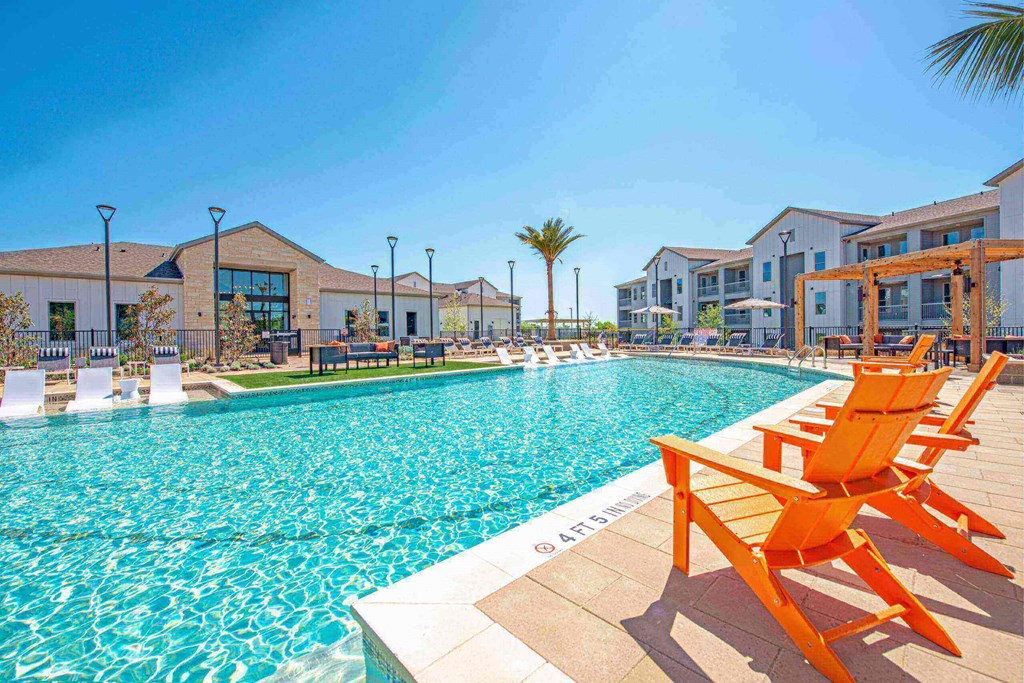 apartments with a swimming pool with orange chairs