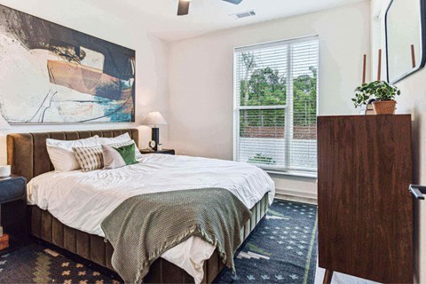 a bedroom with a bed and a painting on the wall