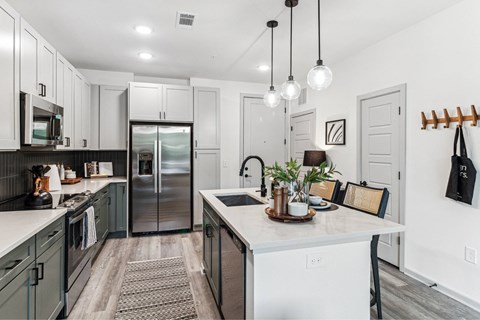 a kitchen with white cabinets and a stainless steel refrigerator