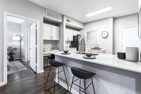 an open kitchen with a counter and bar stools
