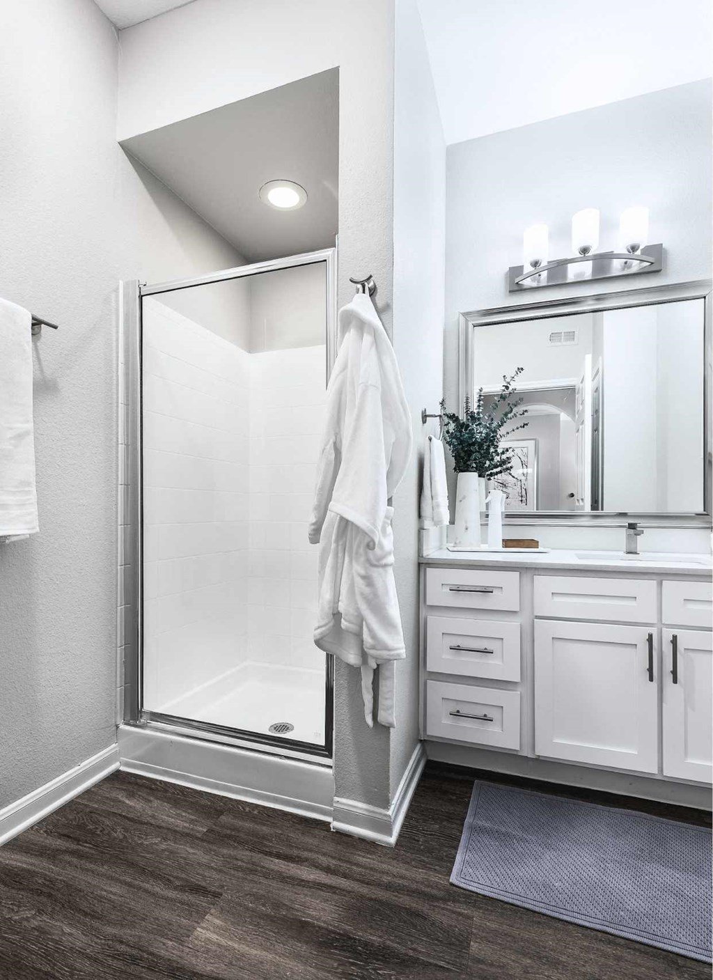a white bathroom with a shower and a sink
