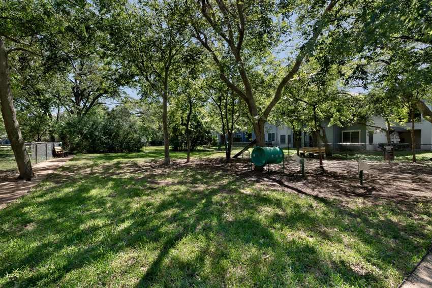 a yard with trees and a house in the background