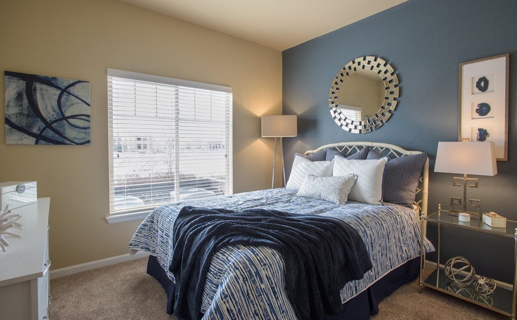 a bedroom with a bed and a mirror on the wall