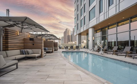 a swimming pool on the rooftop of a building with a city in the background