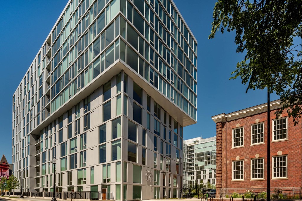 A modern glass building stands next to an older brick building.