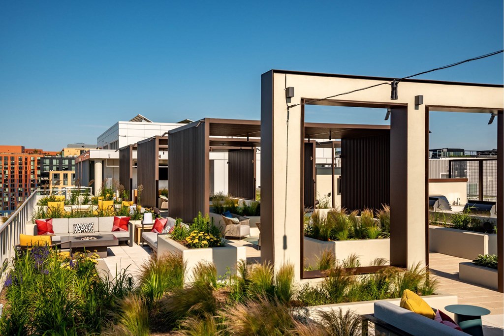 a roof top patio with furniture and plants