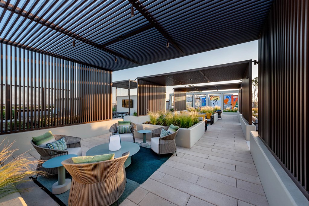 A patio with a table and chairs is surrounded by a black fence.