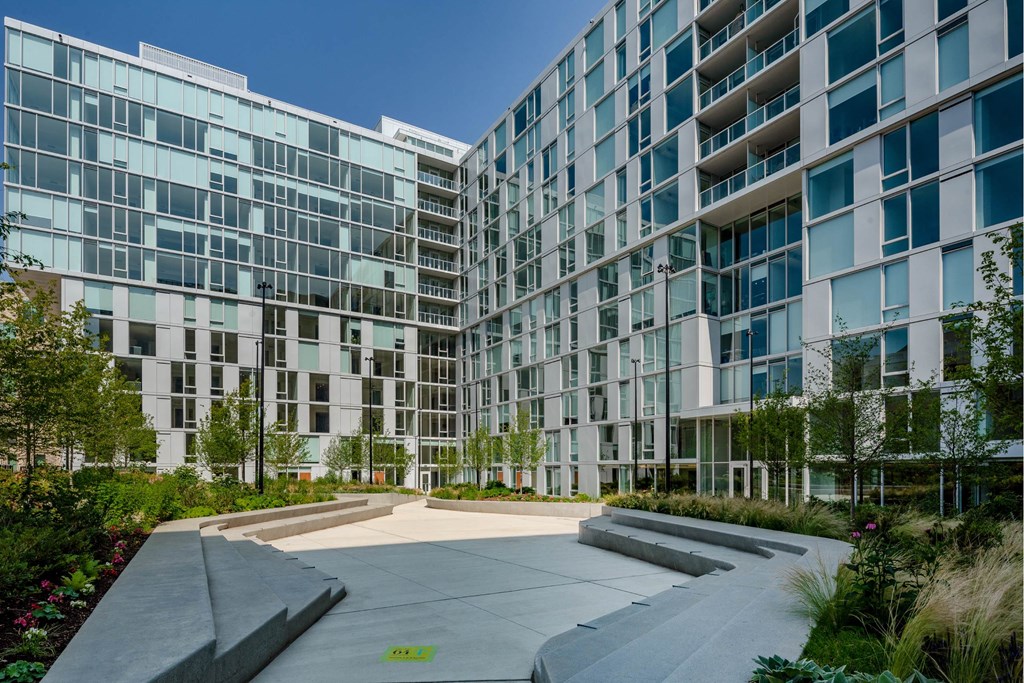 A modern glass building with a walkway in front.