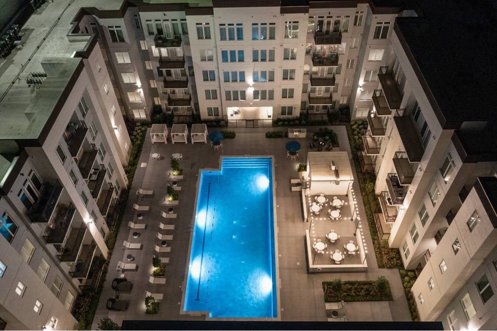 an overhead view of an apartment building with a swimming pool